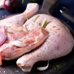 تصویر ران با پوست مرغ تازه و باکیفیت، آماده برای پخت و تهیه غذاهای ترد و خوشمزه.