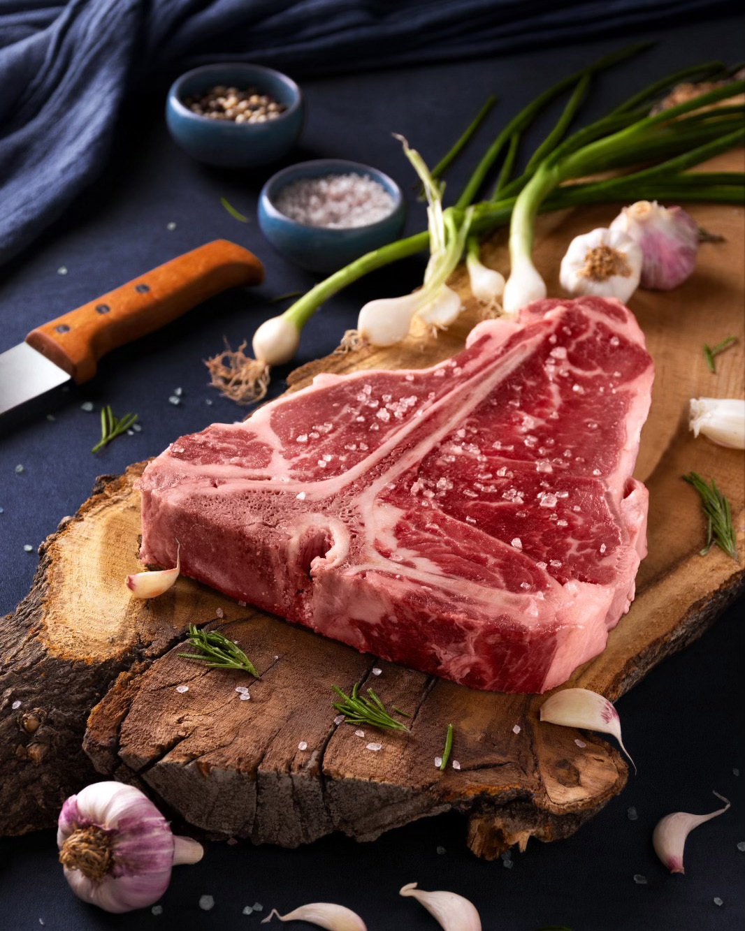 2 تصویر استیک تی بن گوساله با ظاهری خوشمزه و آبدار، آماده برای پخت و سرو با تزئینات جذاب.