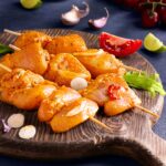 تصویر جوجه‌های تازه مزه‌دار شده با سیر و گوجه‌فرنگی، آماده برای کبابی شدن.